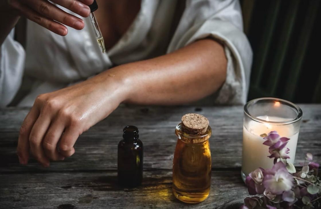 Aromatherapy oils beside a lit candle