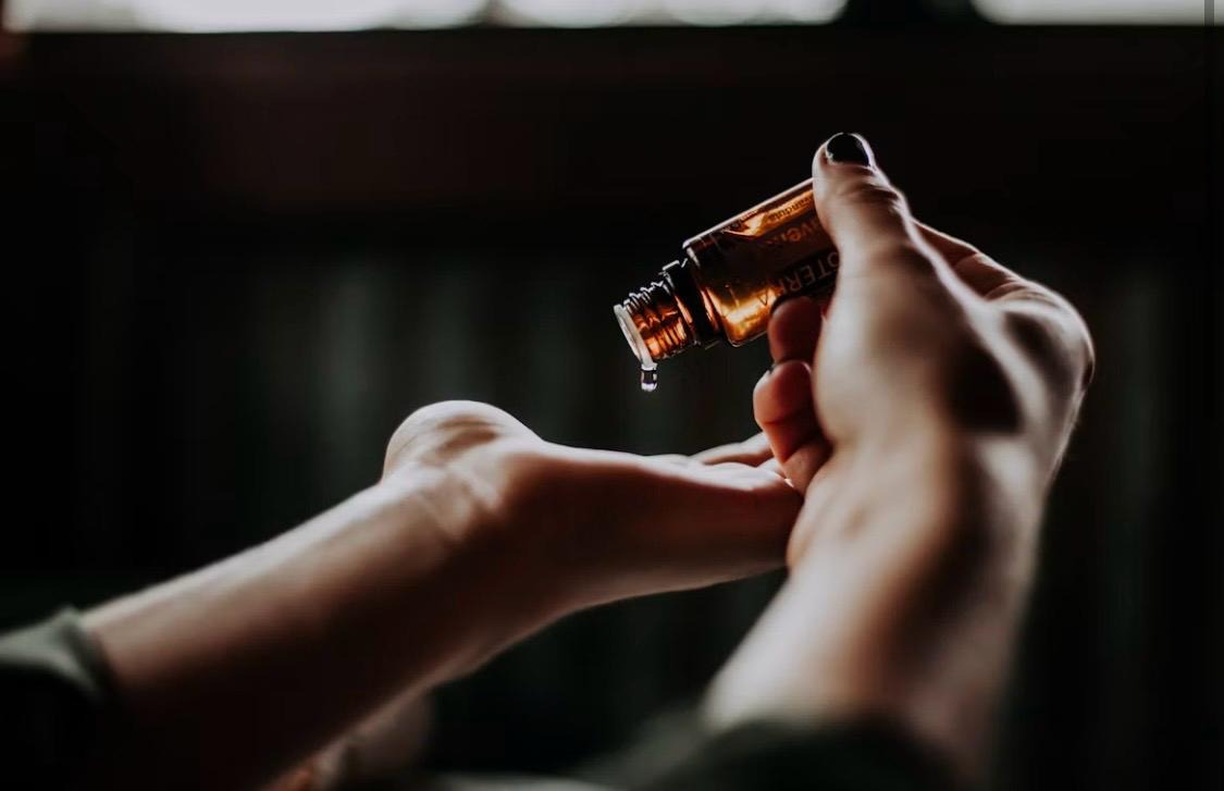 Therapist warming essential oil in her hands